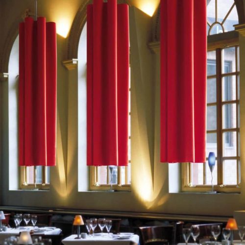 Sala da pranzo di hotel di lusso con lunghe tende rosse