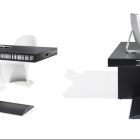 Concept di tavolo nero con una sola gamba che fa anche da cassettiera su sfondo nero