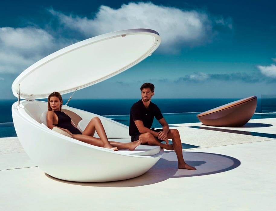Una coppia che prende il sole in un lettino di design fatto ad oblò