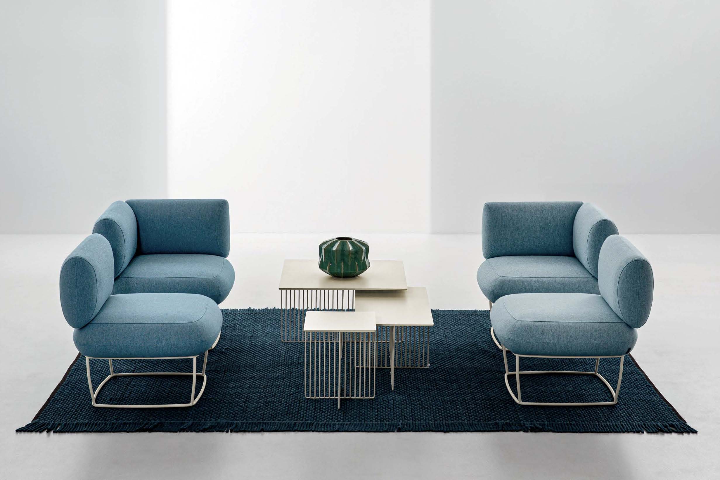 Due divanetti di colore azzurro, uno di fronte all'altro con in mezzo un tavolino