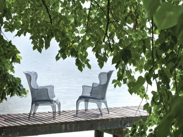 Due sedie su un molo con una cornice di foglie verdi